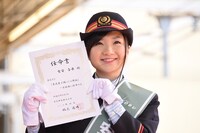 1日駅長の任命書を掲げる有安杏果。