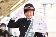 ふじみ野駅の1日駅長の任命書を持って敬礼する有安杏果。