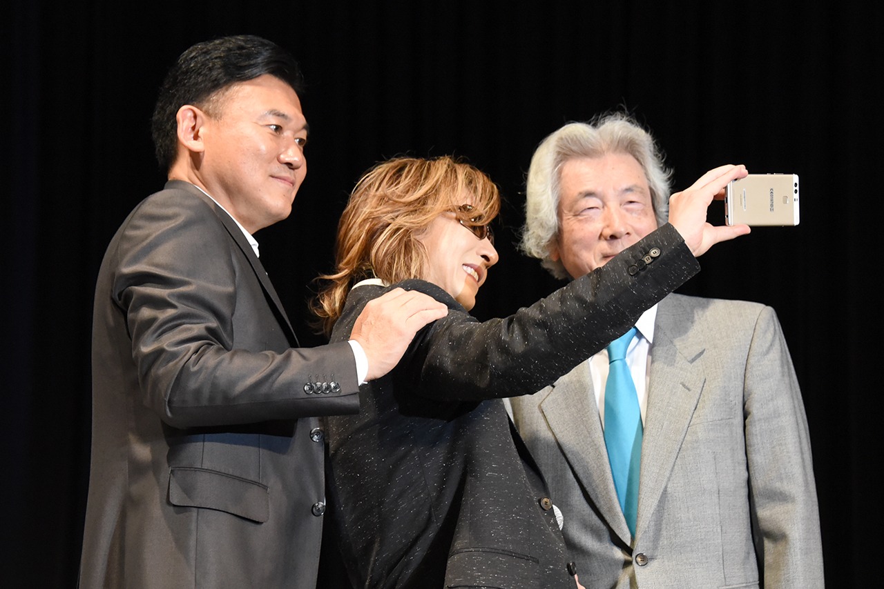 スマートフォンで記念撮影する三木谷社長（左）、YOSHIKI（中央）、小泉純一郎元首相（右）。