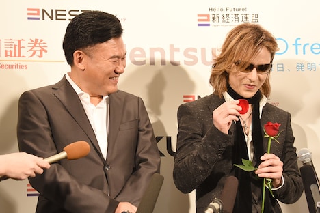 花占いで「アルバムの仕上がりに妥協するかどうか」を占うYOSHIKI(右)とそれを見守る三木谷社長(左)。