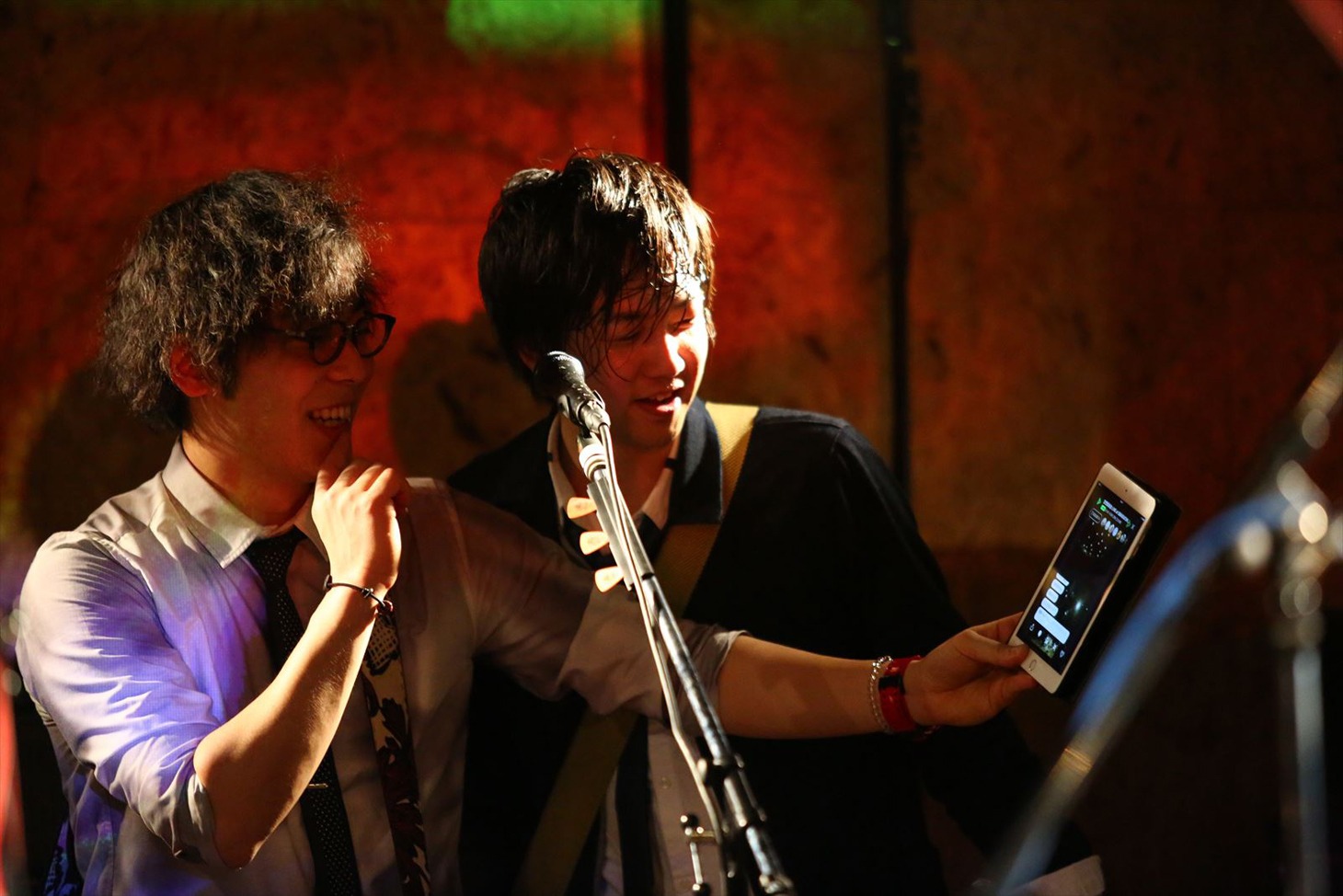 ライブ中にLINE LIVEのコメントを見る三浦隆一（Vo, G）と佐々木直也（G）。（撮影：寒川大輔）