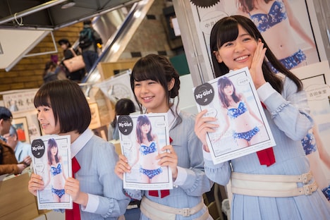 通行人にアピールする高倉萌香（左）、本間日陽（中央）、村雲颯香（右）。(c)AKS