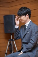 メガネの位置を直す星野源。