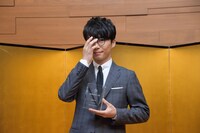 人気画像3位は「星野源、伊丹十三賞贈呈式に登壇『伊丹さんの遺伝子をつないでいきたい』」より、モノリスを片手にメガネの位置を直す星野源。