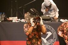 マグロを捌く「たいこ茶屋」若大将（手前）と、真剣にDJをするジョー（奥）。（Photo by Shigeo Kosaka）