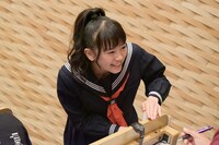 試験を受ける宣伝部員に話しかける坂井仁香。