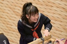 試験を受ける宣伝部員に話しかける坂井仁香。