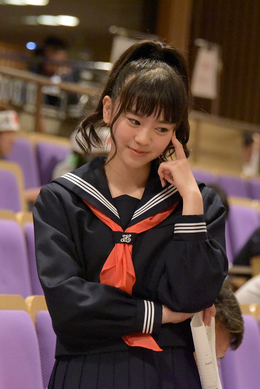 試験を受ける宣伝部員にヒントを出す坂井仁香。