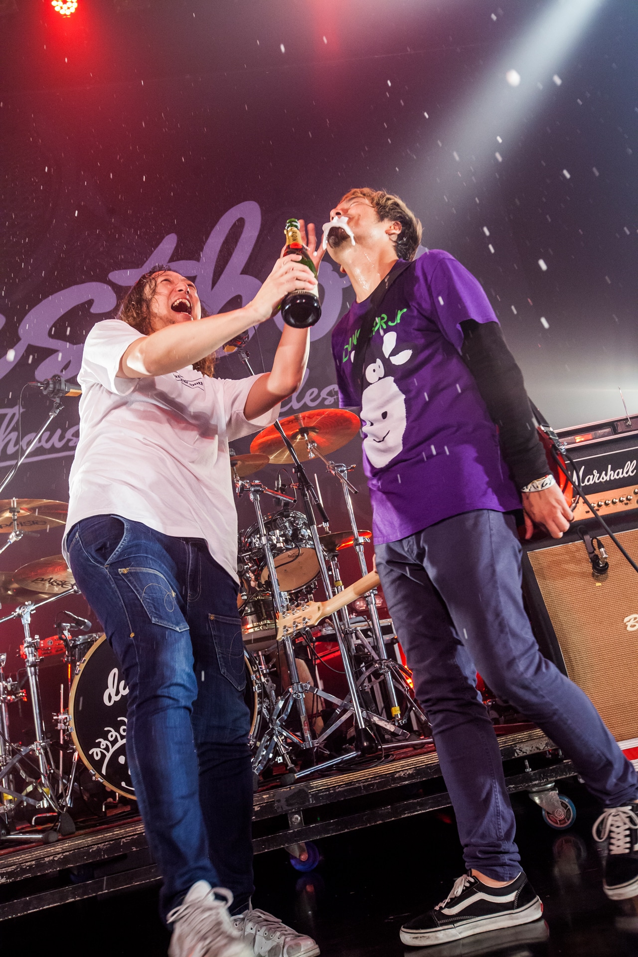 SUGA（Vo, G）にシャンパンを飲ませるJOJI（B, Vo）。（Photo by HayachiN）
