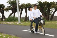 2人乗り自転車を漕ぐ（前から）タカシ、ユースケ。