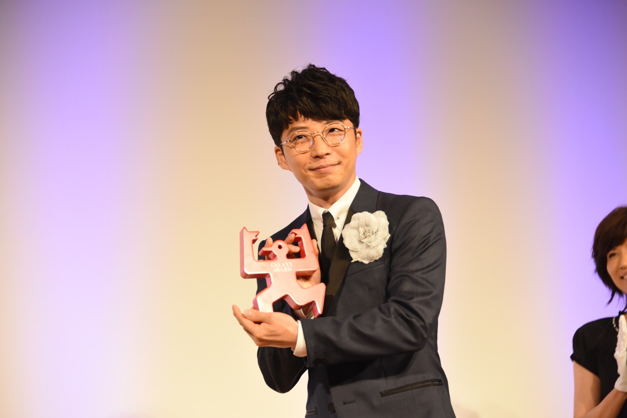 報道陣にトロフィーを見せる星野源。