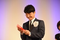 トロフィーを見つめる星野源。