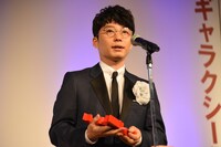 トロフィーを手にスピーチを行う星野源。