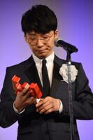 トロフィーを凝視する星野源。