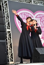 広場の奥にいるエビ中ファミリーが背伸びしないと見えないと嘆く真山りか（左）。