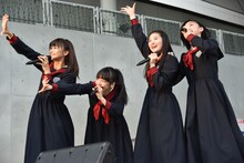 広場の奥にいるエビ中ファミリーに手を振る星名美怜、真山りか、柏木ひなた、小林歌穂（左から）。