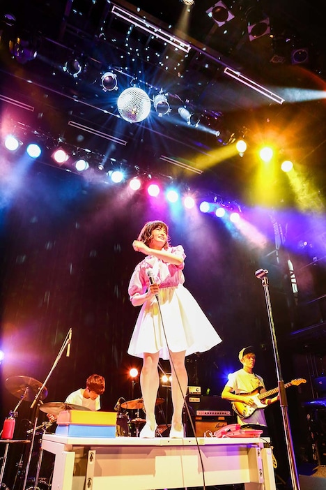 「出会ってから付き合うまでのあの感じ」を机の上に立って歌うSHE IS SUMMER。（撮影：落合由夏）