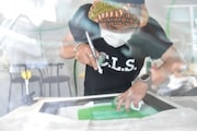「Suchmosロゴステンシルスポット」でのスプレー中の様子。