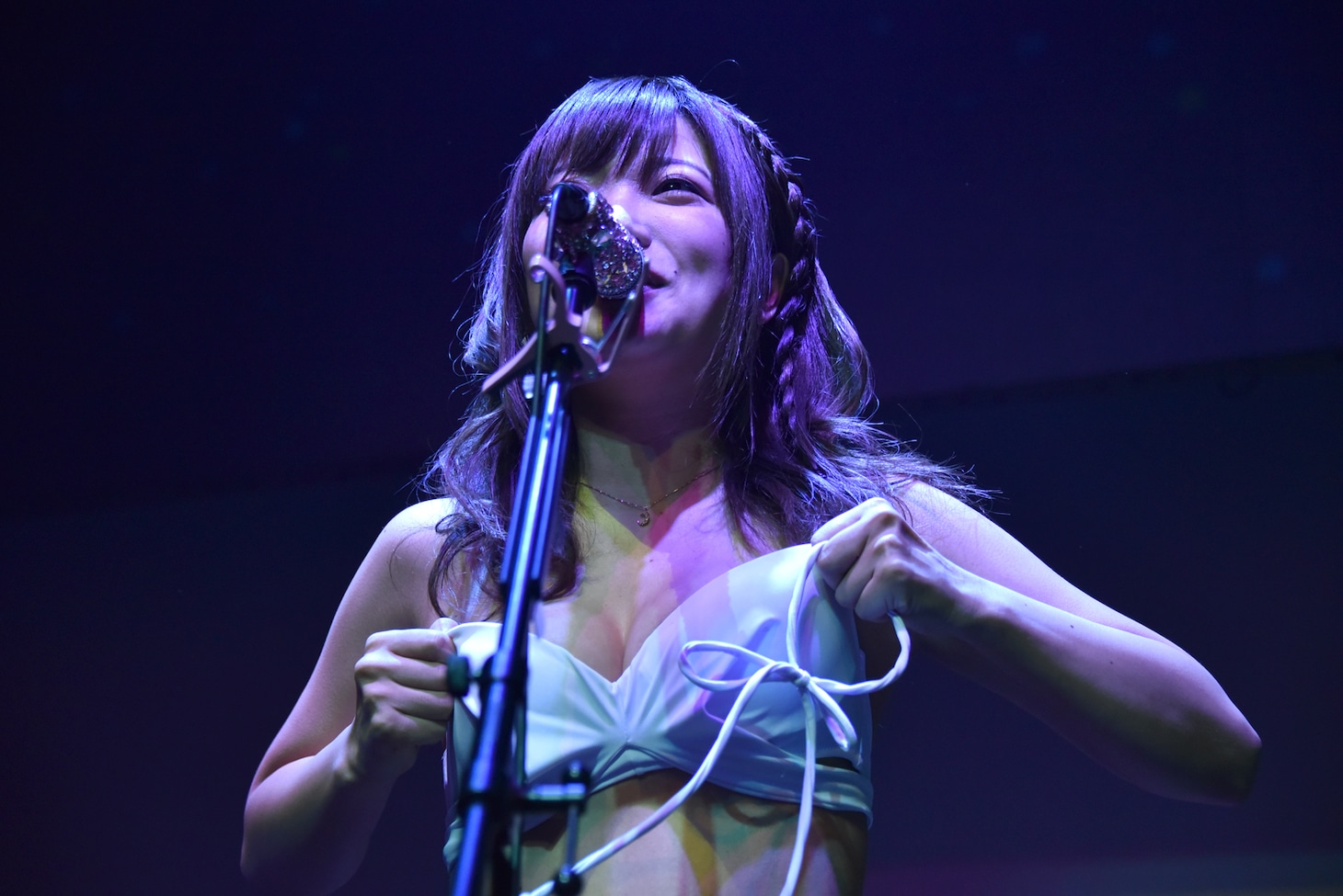 肩紐の外れたビキニを手で押さえながら歌う藤田恵名。