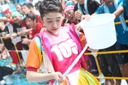 外れたバケツの取っ手を見つめる小泉遥香。（撮影：マキノタカヒコ）