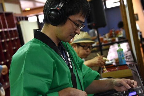 DJをするconnie（手前）と弁当を食べる熊さん（奥）。