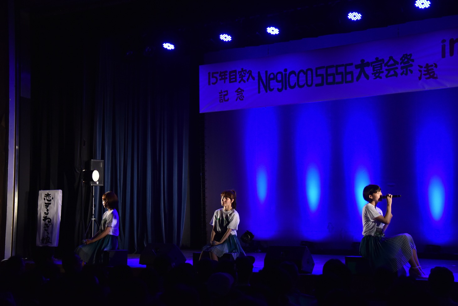 ステージ端に座って「愛は光」を歌うNegicco。