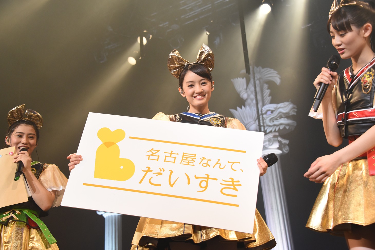 「名古屋なんて、だいすき」のボードを持った咲良菜緒（中央）。