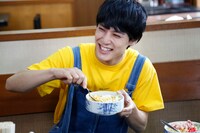 笑顔でお好み焼きの具を混ぜるユースケ。