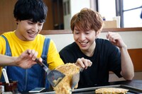 お好み焼きを返すユースケと見守るコーイチ。