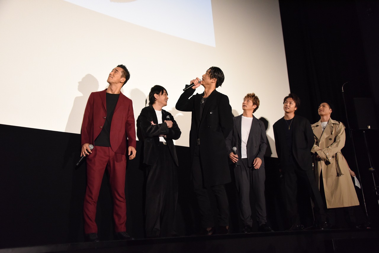 スクリーンを見上げる登壇者たち。