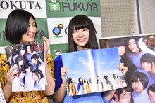 カバーを取り外して表紙を見せる中山莉子（右）。