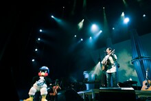 「つばめよつばめ」を歌うさだまさしと、座って聴くつば九郎。