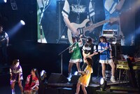 ギターソロを弾くバンマス・手島いさむを囲むたこやきレインボー。