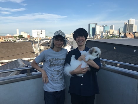 本秀康（左）とカクバリズム社長・角張渉氏（右）。角張氏が抱いているのは本の愛犬・モコゾウ。