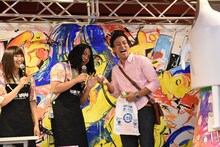 当たりを引いたファンとポーズを決めるもりもりもと（Dr, Cho）。