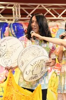 サイン入りドラムヘッドを見せるもりもりもと（Dr, Cho）。