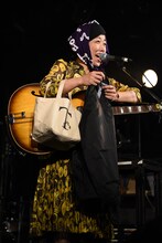 T字路sのグッズを紹介する伊東妙子（Vo, G）。