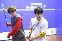 スカッシュをしながら番組を進行する「次ナルTV-G」MCの（左から）ユーキ、ユースケ。