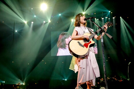 アコースティックギターで弾き語りを披露する有安杏果。（写真提供：キングレコード）