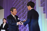トロフィーを受け取る星野源。
