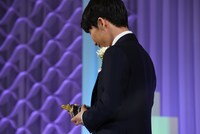 トロフィーを見つめる星野源。