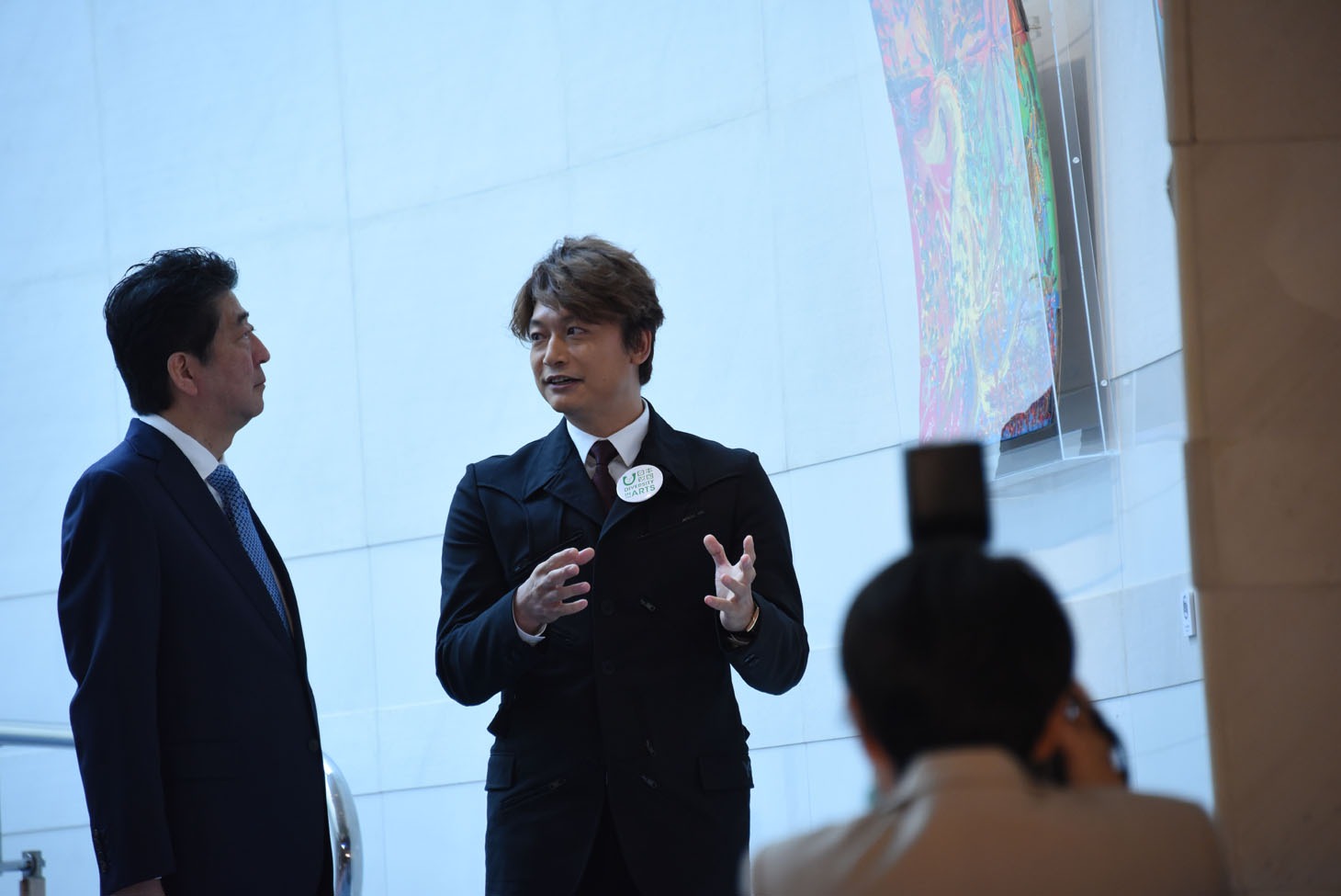 安倍晋三首相（左）に自身の作品の解説をする香取慎吾（右）。