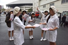 アイドルネッサンスのファンが集まる開演前の会場入口で告知チラシを配る妹分的グループ・AIS -All Idol Songs-。