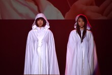 純白のフードマントをまとった石野理子（左）と南端まいな（右）。