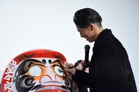 だるまに目を入れるAKIRA。