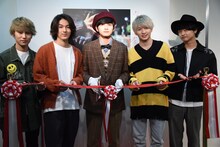 テープカットをする北村匠海（中央）と、祝福するメンバー。