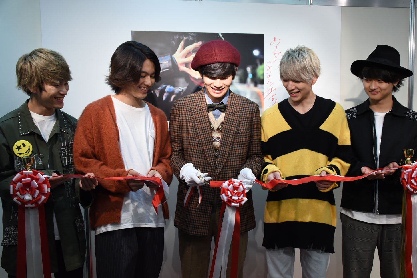 テープカットをする北村匠海（中央）と、彼を見守るメンバー。