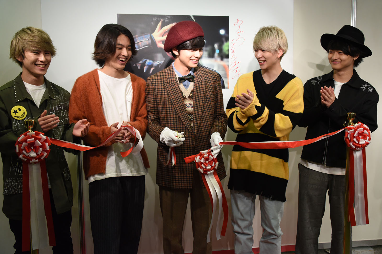 テープカットした北村匠海（中央）と、祝福するメンバー。
