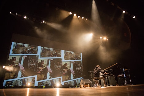 スクリーンに映し出されたIKUO（B / BULL ZEICHEN 88、Rayflower）、淳士（Dr / SIAM SHADE、BULL ZEICHEN 88）のパフォーマンス映像とコラボするまらしぃ。（撮影：石阪大輔）