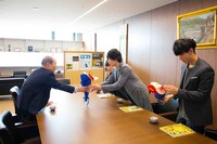 塩崎均学長からアンスリウムをプレゼントされるflumpool。（撮影：森好弘）